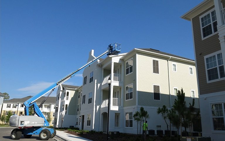 condo complex with cherry picker on roof