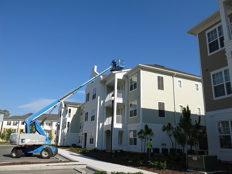 condo complex with cherry picker on roof